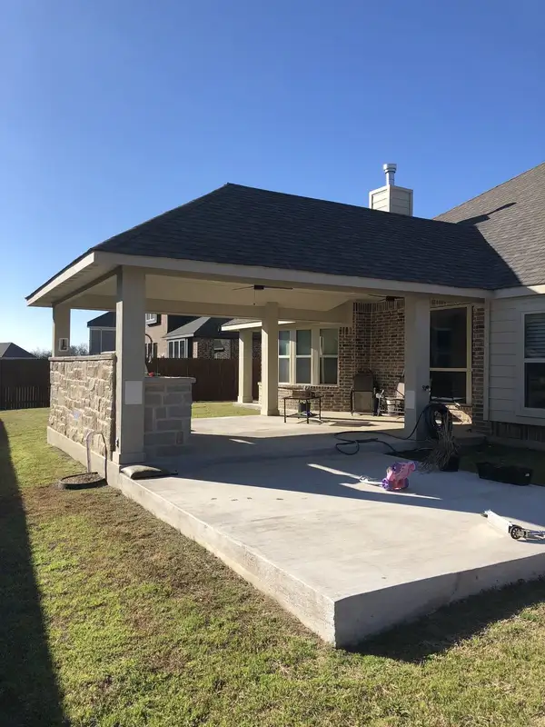 Hip-roof patio cover with a stone veneer counter wall and sink over a large concrete patio
